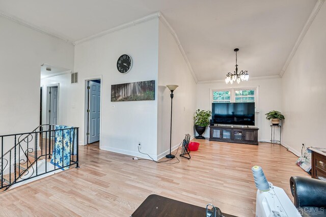 living room with light hardwood / wood-style flooring, a notable chandelier, and ornamental molding