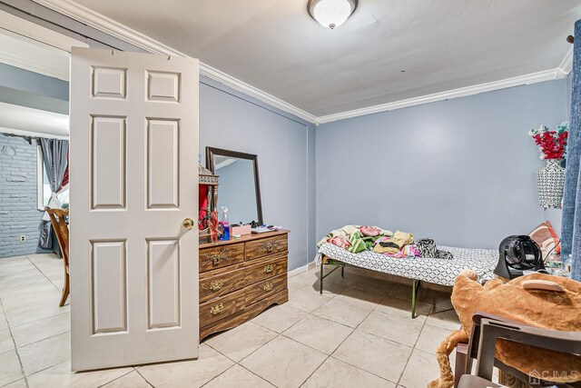 bedroom with ornamental molding and light tile patterned floors