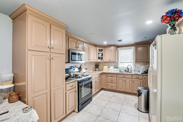 kitchen featuring light tile patterned flooring, white refrigerator with ice dispenser, light stone countertops, black gas range, and sink