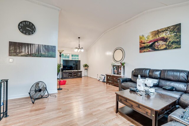 living room featuring an inviting chandelier, light hardwood / wood-style flooring, ornamental molding, and lofted ceiling