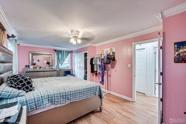 bedroom featuring ceiling fan, ornamental molding, a closet, and light hardwood / wood-style floors