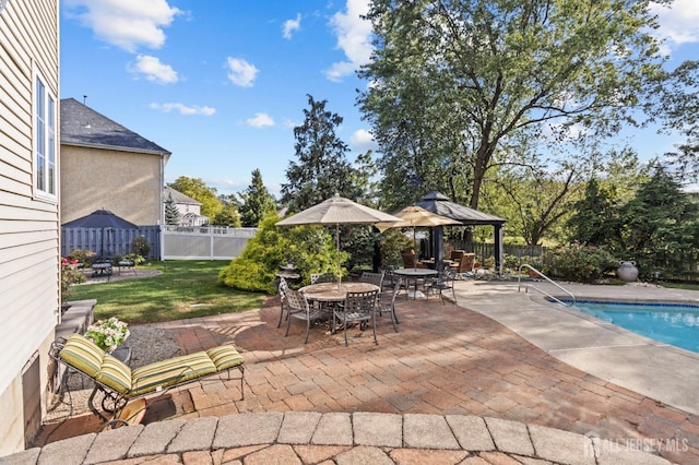 view of patio / terrace featuring a gazebo, a fenced in pool, a fenced backyard, and outdoor dining space