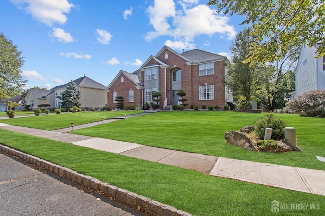 view of front facade featuring brick siding and a front lawn