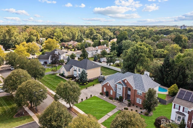 drone / aerial view featuring a residential view and a view of trees