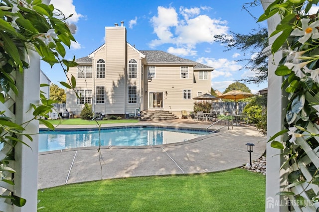 view of pool with a fenced in pool, fence, entry steps, a patio area, and a lawn