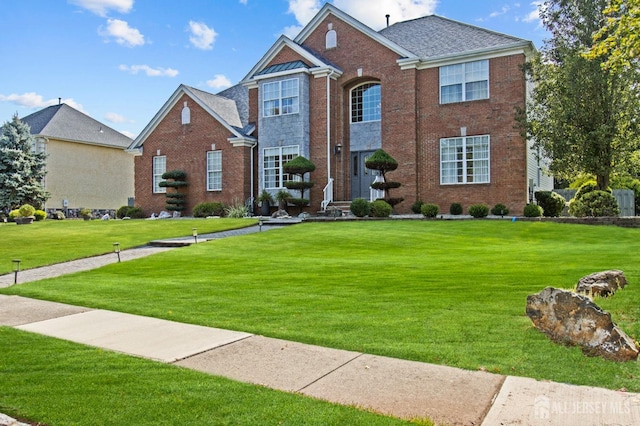 view of front of house with brick siding and a front yard