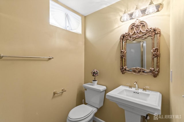 bathroom with toilet, baseboards, and a sink