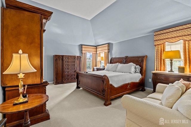 carpeted bedroom with vaulted ceiling and baseboards