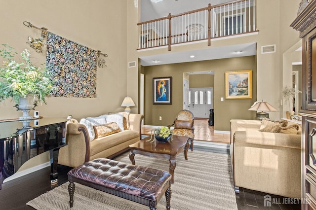 living area with baseboards and visible vents