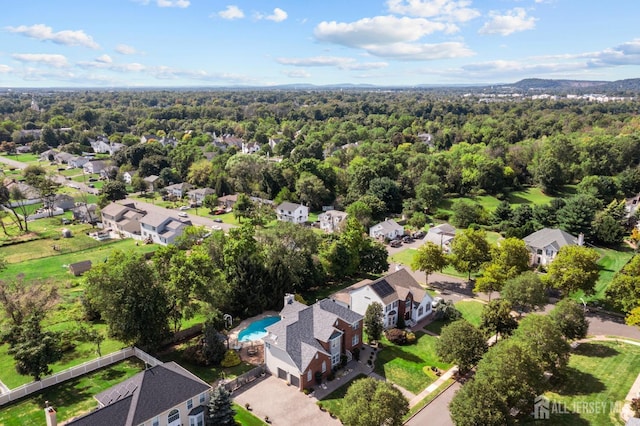 bird's eye view featuring a wooded view and a residential view