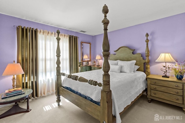 carpeted bedroom featuring visible vents