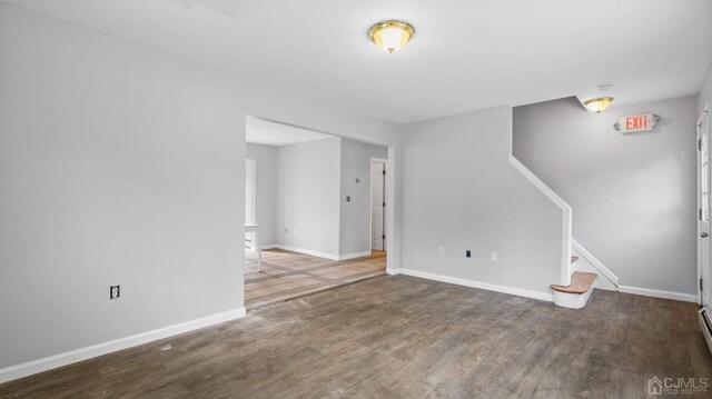 empty room with dark hardwood / wood-style flooring