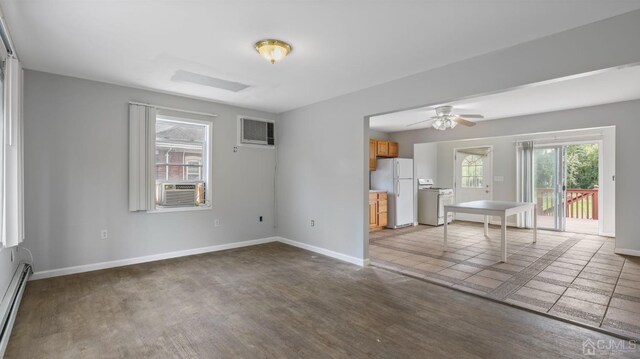 spare room with ceiling fan, a wealth of natural light, wood-type flooring, and a baseboard radiator