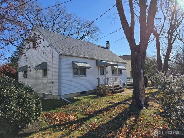 rear view of property featuring a lawn