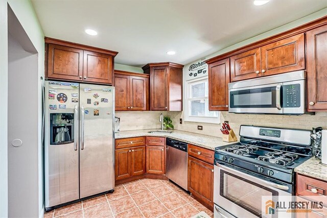 907 Maple Hill Dr Unit 907, Woodbridge Proper, NJ 07095 - kitchen with appliances with stainless steel finishes, decorative backsplash, light stone counters, light tile patterned flooring, and recessed lighting
