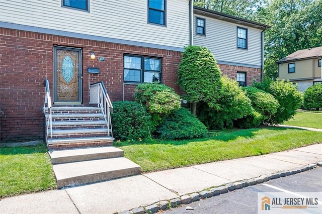 907 Maple Hill Dr Unit 907, Woodbridge Proper, NJ 07095 - doorway to property featuring brick siding and a yard
