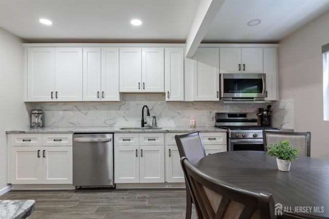 kitchen featuring appliances with stainless steel finishes, dark hardwood / wood-style floors, white cabinetry, and sink