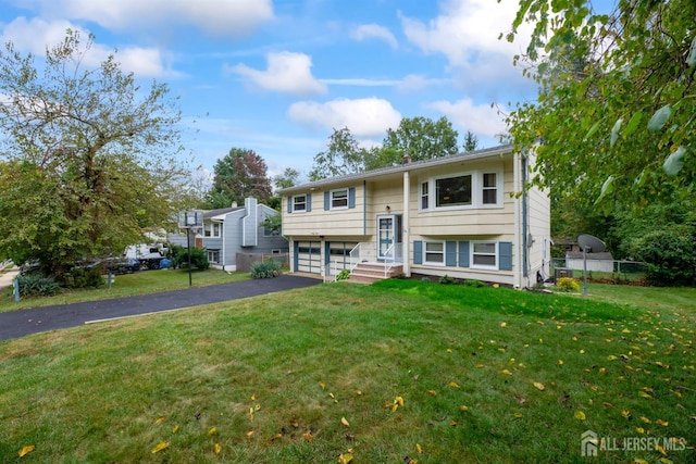 split foyer home with a garage and a front lawn