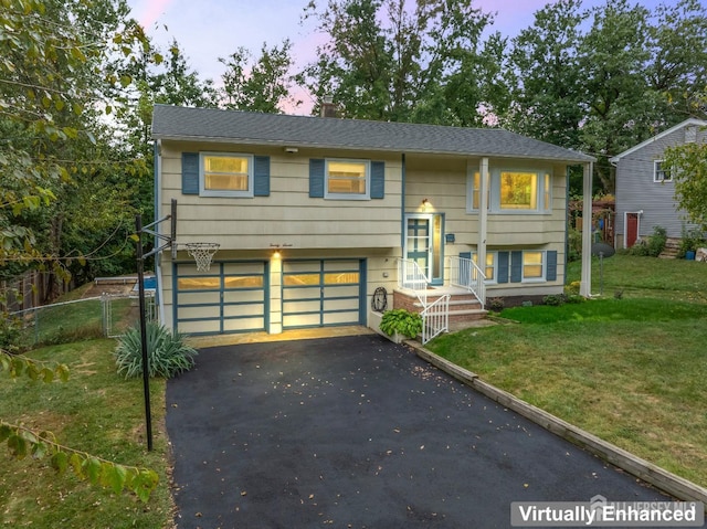 split foyer home with a yard and a garage