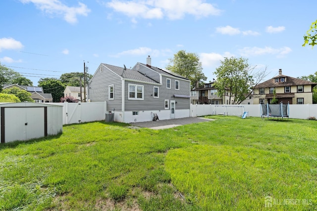 315 D St, Middlesex, NJ 08846 - back of house featuring a fenced backyard, a trampoline, a storage shed, a patio, and a chimney