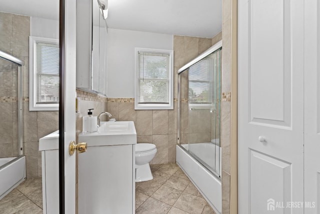 315 D St, Middlesex, NJ 08846 - full bathroom with tile walls, vanity, combined bath / shower with glass door, tile patterned floors, and wainscoting