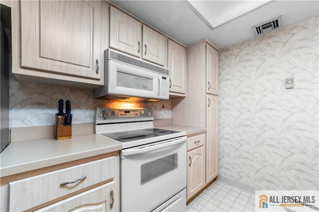 kitchen with light countertops, white appliances, light floors, and visible vents