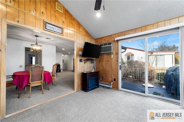 interior space featuring a textured ceiling, wood walls, visible vents, vaulted ceiling, and carpet