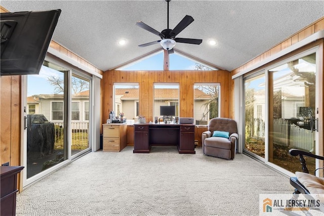 office with light carpet, wooden walls, vaulted ceiling, and a textured ceiling