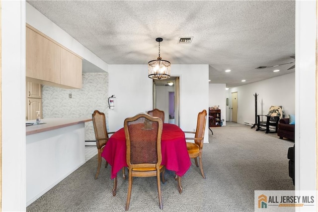 dining room featuring carpet flooring, visible vents, a textured ceiling, and an inviting chandelier