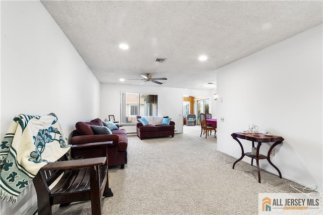 carpeted living area featuring a textured ceiling, ceiling fan, visible vents, and recessed lighting