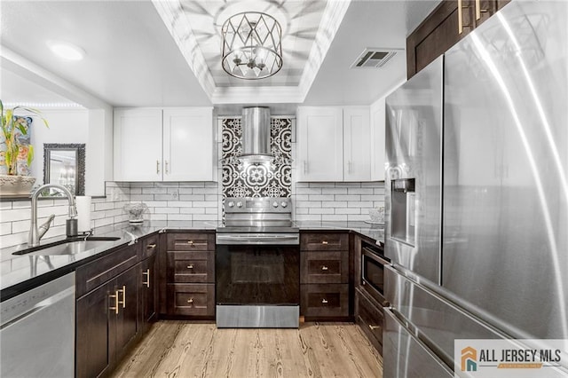 275 Convent Rd Unit 275A, Monroe, NJ 08831 - kitchen featuring stainless steel appliances, a raised ceiling, dark brown cabinetry, wall chimney exhaust hood, and white cabinets