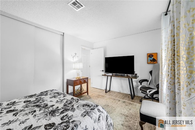 275 Convent Rd Unit 275A, Monroe, NJ 08831 - bedroom with wood finished floors, a textured ceiling, and a closet