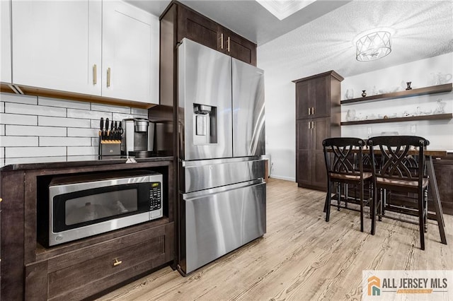 275 Convent Rd Unit 275A, Monroe, NJ 08831 - kitchen featuring stainless steel appliances, dark brown cabinetry, light wood-style floors, open shelves, and tasteful backsplash