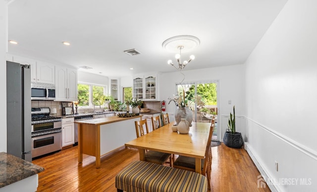 101 Weston Rd, Franklin, NJ 08873 - dining area featuring a baseboard radiator, wood finished floors, a chandelier, and recessed lighting