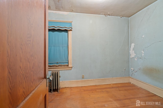 183 State St, Perth Amboy, NJ 08861 - spare room featuring radiator heating unit and wood finished floors