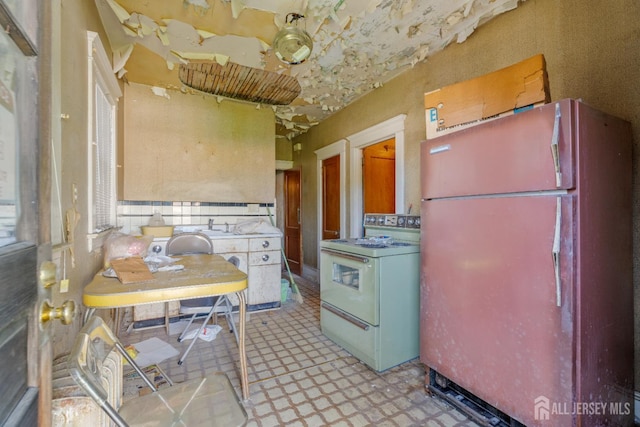 183 State St, Perth Amboy, NJ 08861 - kitchen with freestanding refrigerator, white range with gas stovetop, and light floors