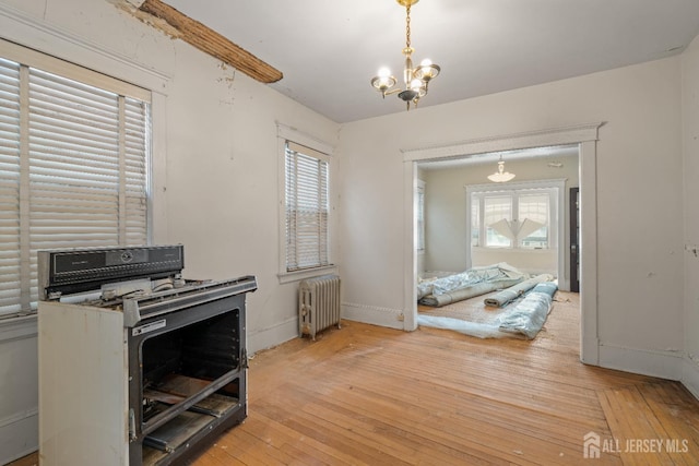 183 State St, Perth Amboy, NJ 08861 - kitchen with radiator heating unit, gas stove, baseboards, light wood-style flooring, and a chandelier