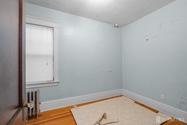 183 State St, Perth Amboy, NJ 08861 - unfurnished room with radiator, wood finished floors, and baseboards