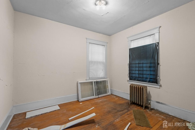 183 State St, Perth Amboy, NJ 08861 - spare room with radiator, wood-type flooring, and baseboards