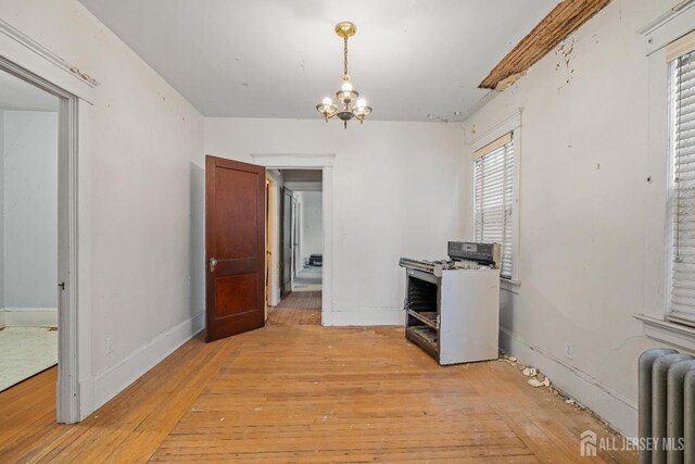 183 State St, Perth Amboy, NJ 08861 - unfurnished office with radiator heating unit, light wood-style floors, a chandelier, and baseboards