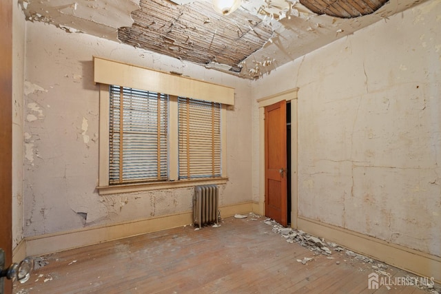 183 State St, Perth Amboy, NJ 08861 - empty room featuring radiator heating unit and hardwood / wood-style floors