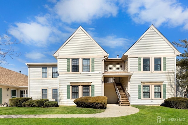 view of front of property featuring stairs and a front lawn