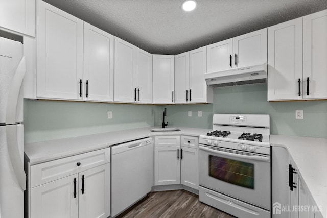 kitchen featuring white cabinets, under cabinet range hood, and white appliances