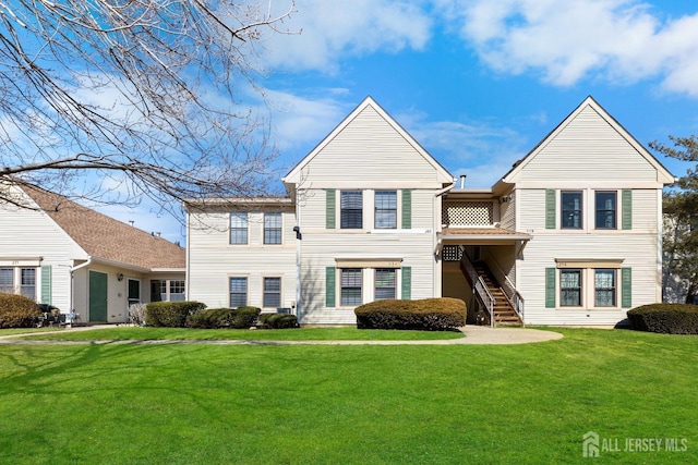 view of front of house with stairway and a front yard