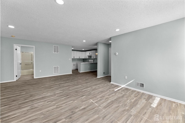 unfurnished living room with visible vents and baseboards