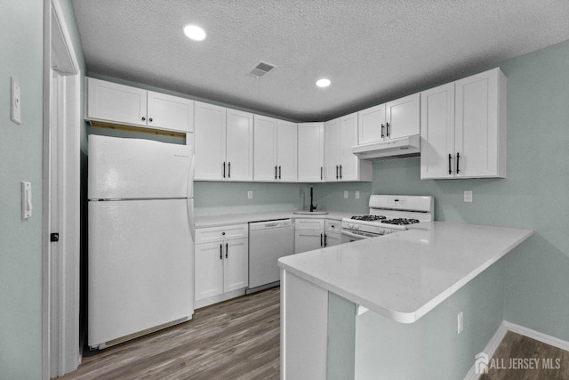 kitchen featuring visible vents, white cabinetry, wood finished floors, white appliances, and under cabinet range hood