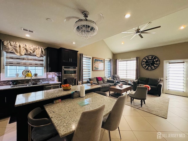 kitchen with a sink, dark cabinetry, visible vents, and open floor plan