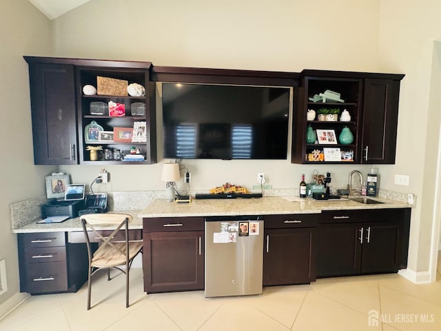 bar with a sink, wet bar, light tile patterned floors, and refrigerator