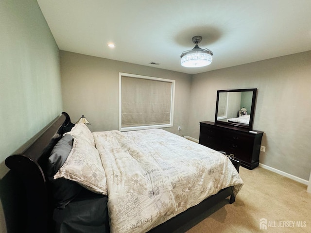 bedroom with baseboards, light carpet, and visible vents