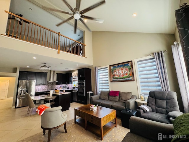 living area featuring light tile patterned floors, high vaulted ceiling, a ceiling fan, and recessed lighting